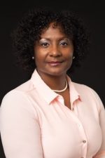 Portrait of Danielle Y. Hairston Green. Green directly to camera and has a faint smile. She is wearing a light pink collared shirt.